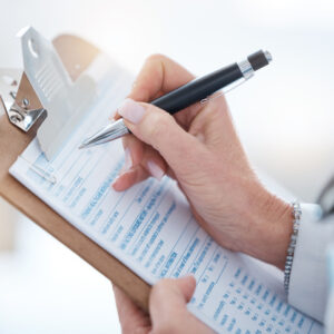 Woman, doctor hands and writing on clipboard, checklist and healthcare consulting information. Closeup medical worker write documents, data and questions for report, planning or clinic administration